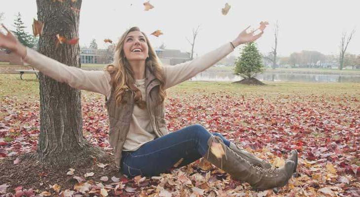 Student playing in fall leaves